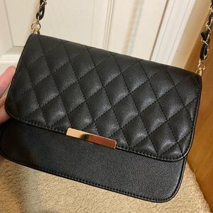 Black quilted cross body purse with gold chair detail and patchwork stitching